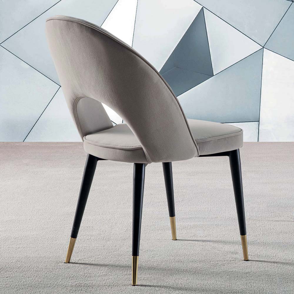 Sedia moderna in velluto beige con gambe nere e punte dorate, ideale per soggiorno o sala da pranzo