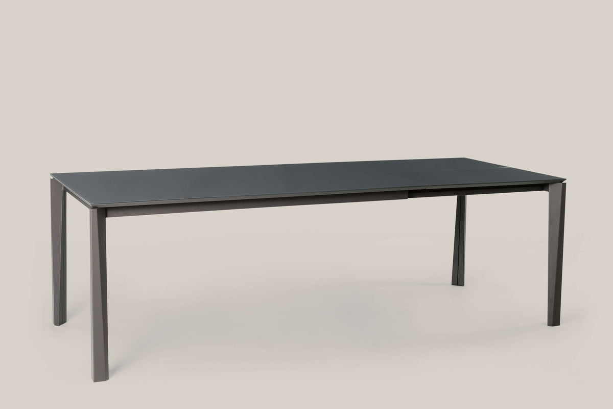 Tavolo Ingenia Prisma allungabile in metallo laccato, superficie liscia e design moderno, con estensione visibile.
