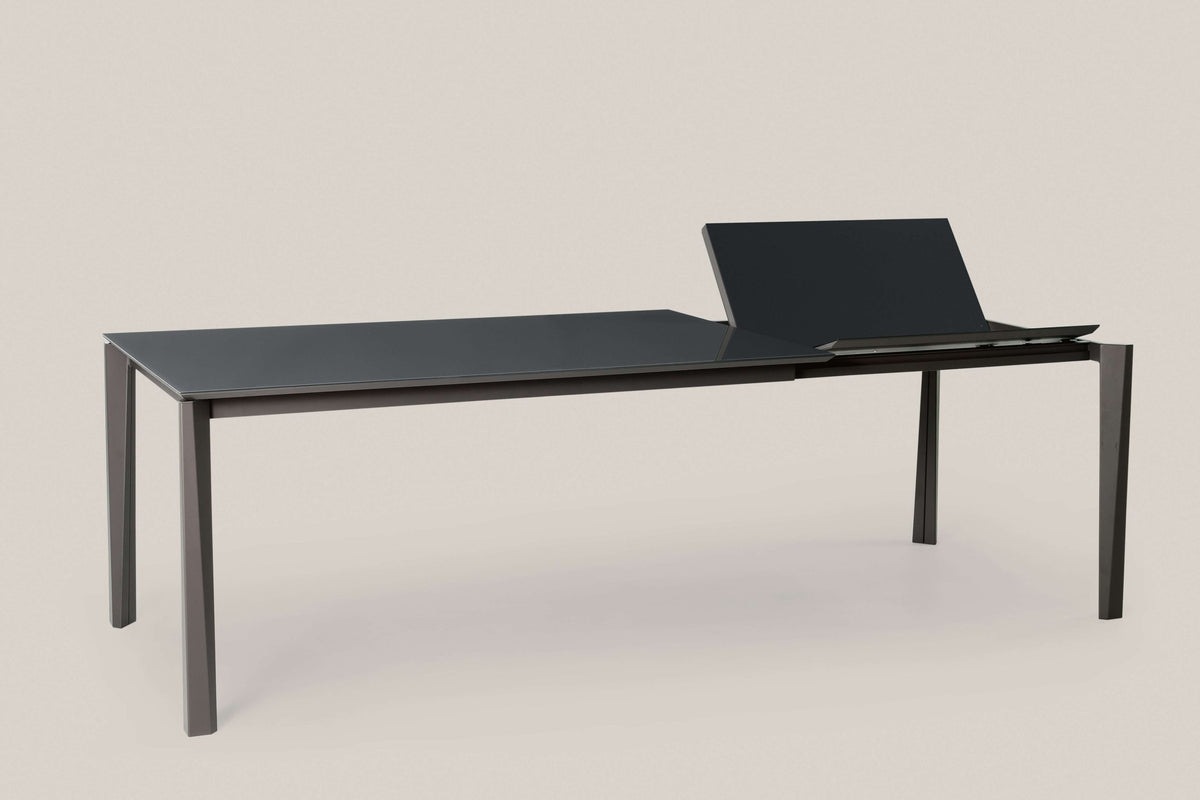 Tavolo Prisma allungabile Ingenia con piano in metallo laccato, design moderno e struttura stabile, vista dall'angolazione.