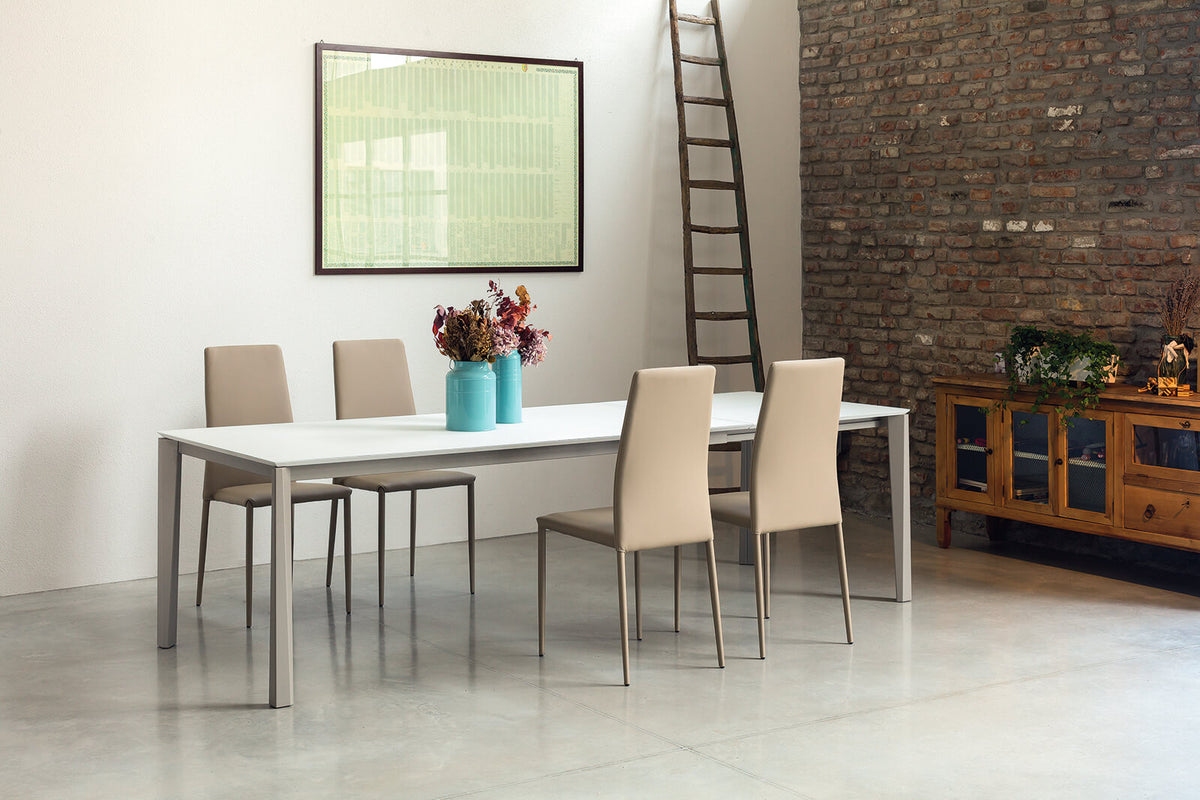 Tavolo allungabile Ingenia Prisma con piano in metallo laccato bianco, struttura robusta e design moderno.